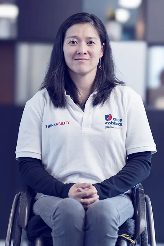 Woman in wheelchair sits and looks at the camera