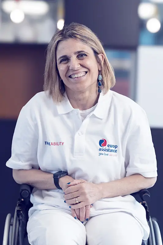 Woman in wheelchair sits and looks at the camera