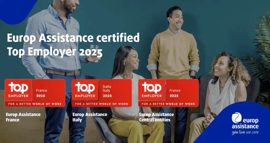 Four professionals talking in front of a wall displaying Europ Assistance's Top Employer 2025 certifications